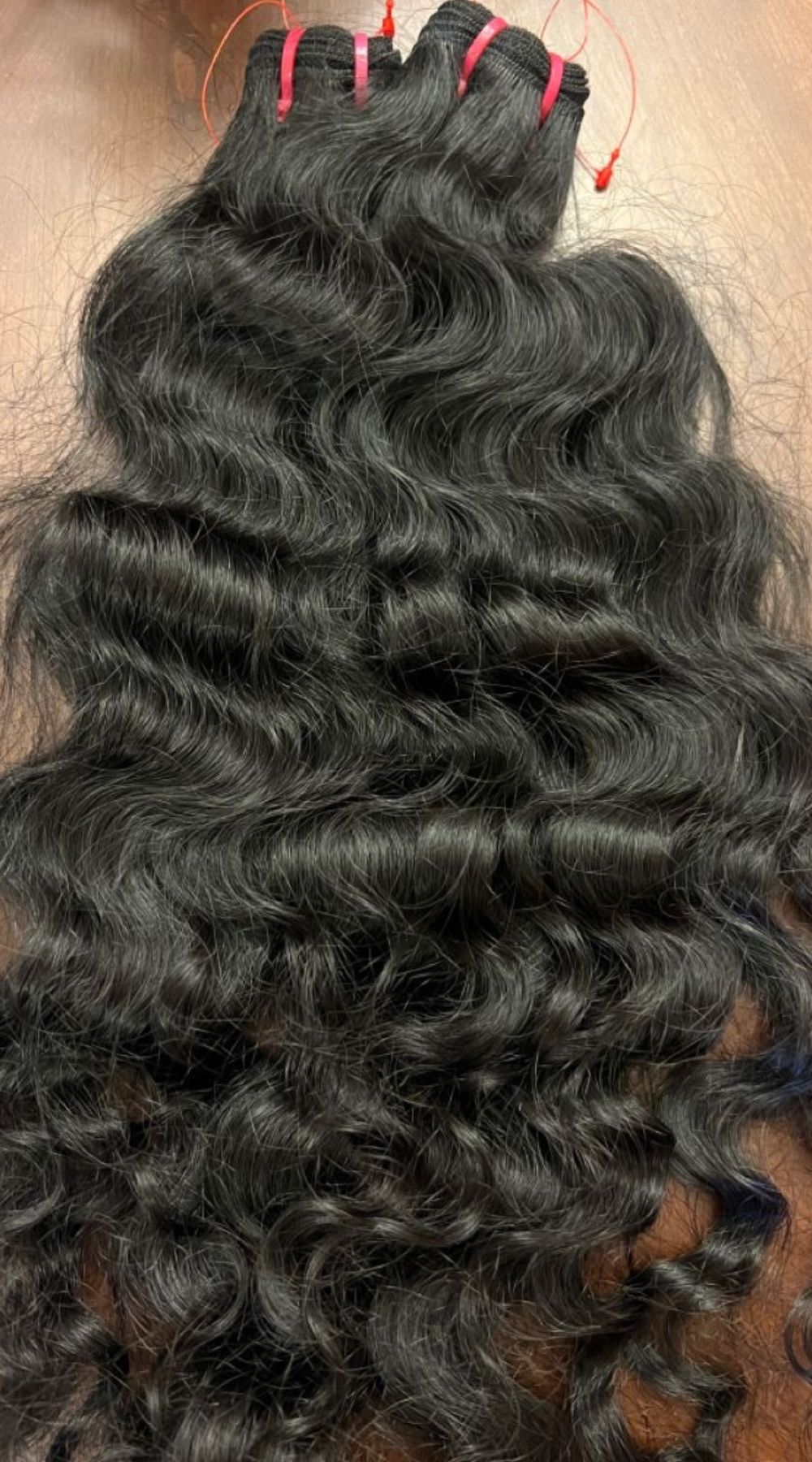 Tissage curly en cheveux bruts, boucles naturelles et volumineuses, texture authentique et résistante.