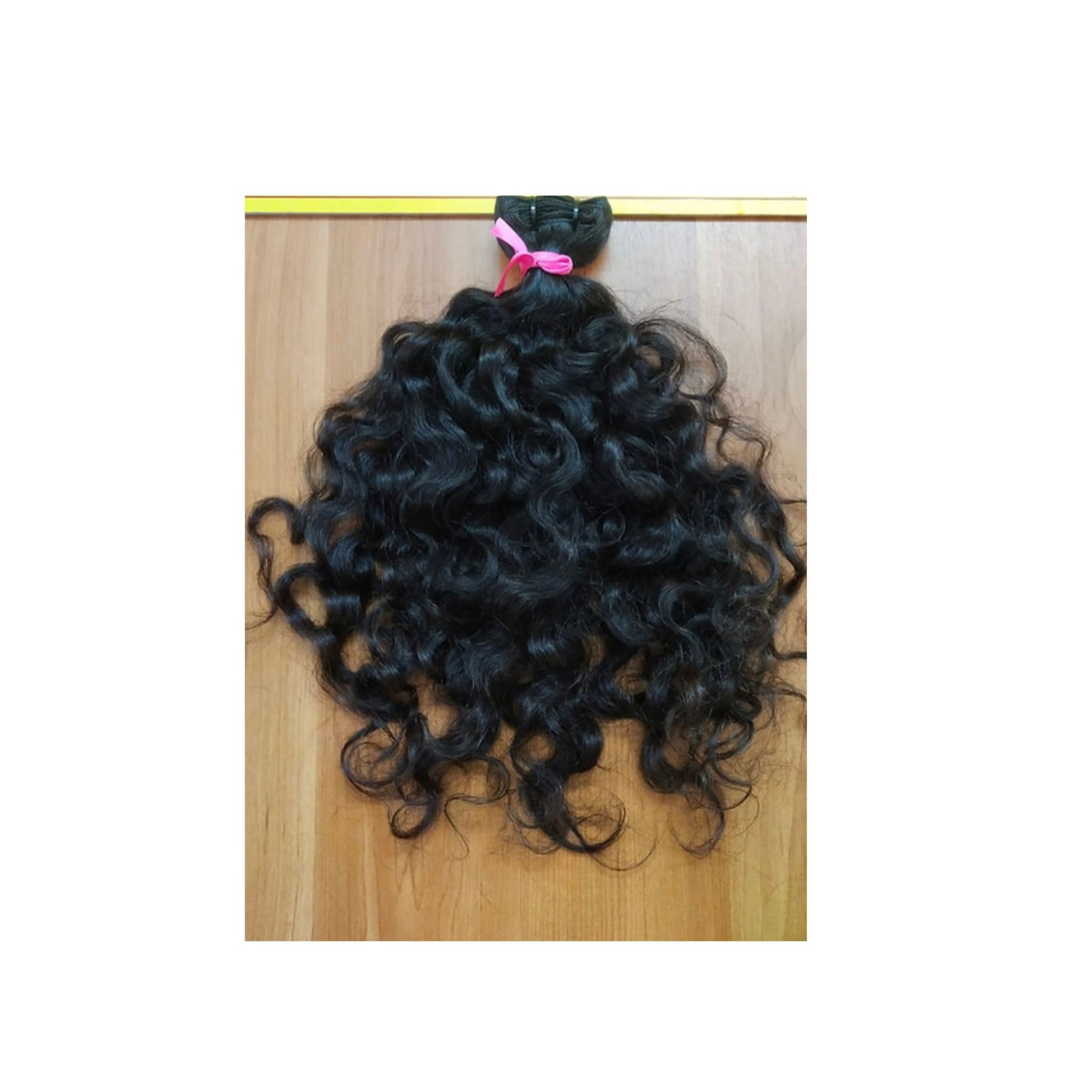 Tissage curly en cheveux bruts, boucles naturelles et volumineuses, texture authentique et résistante."