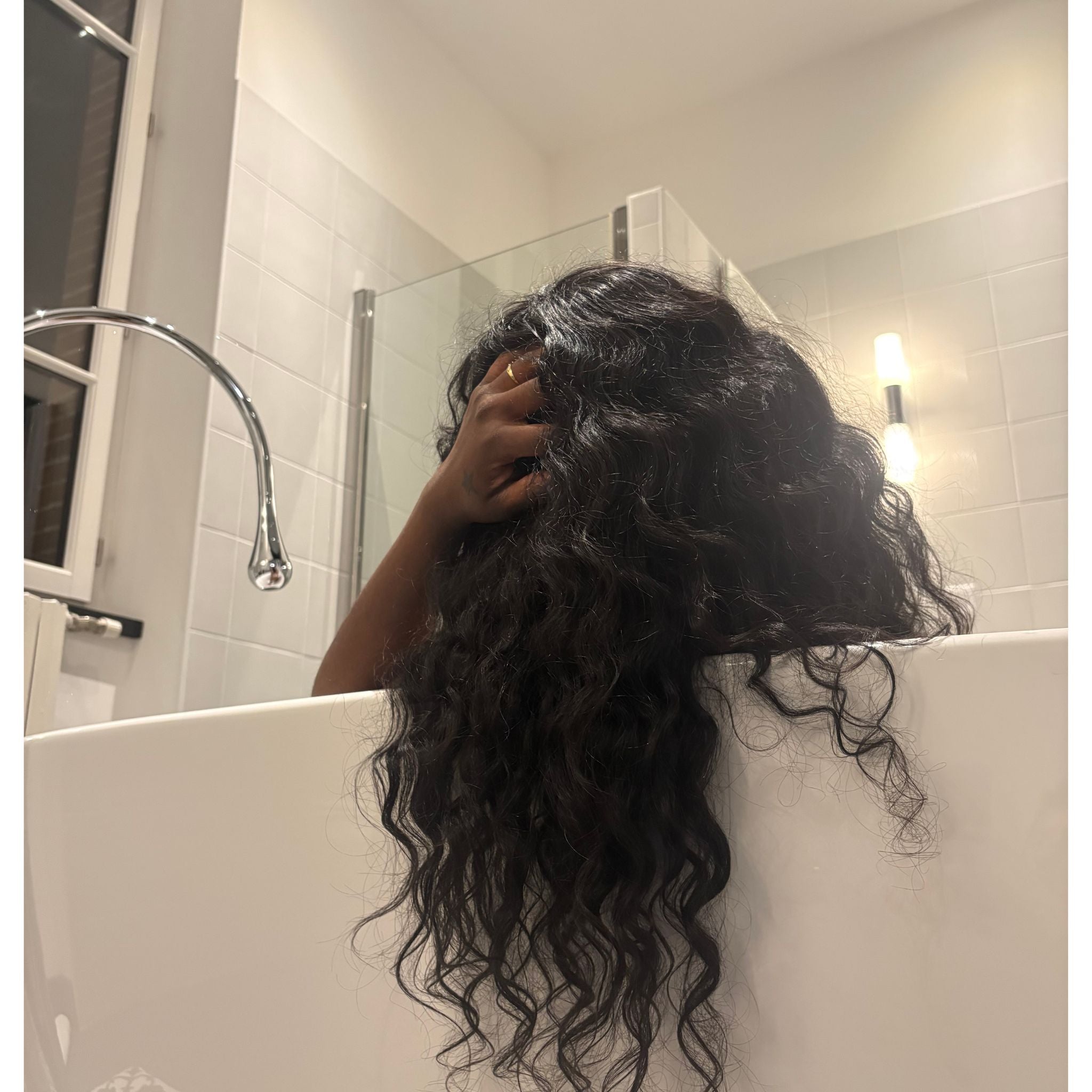 Perruque bouclée en cheveux bruts indiens, texture naturelle et boucles définies pour un look volumineux et élégant.